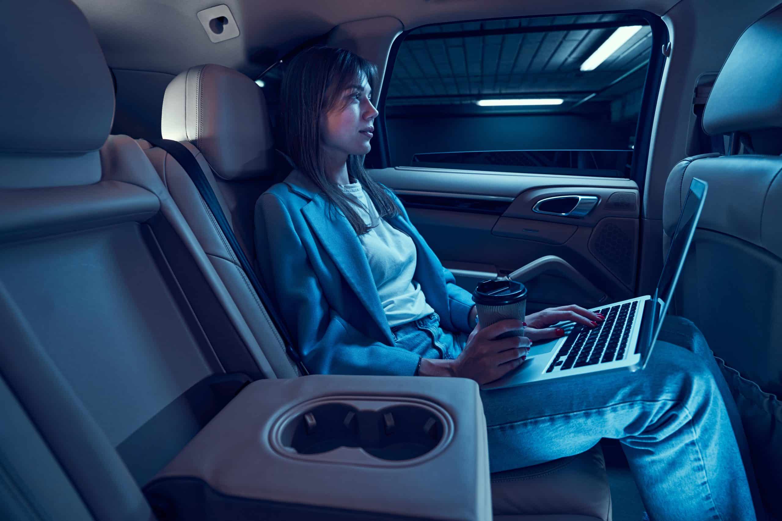Interior view of a business traveler using laptop in a premium SUV, CMB Transport delivers efficient, quiet transport for Minnesota professionals on the move