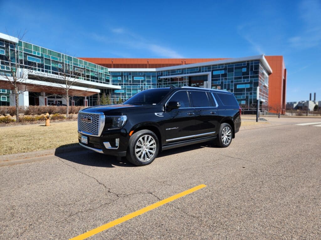 Corporate Car Services in Minneapolis. Book your next professional event ride today! Black Esclade in fron of a corporate office