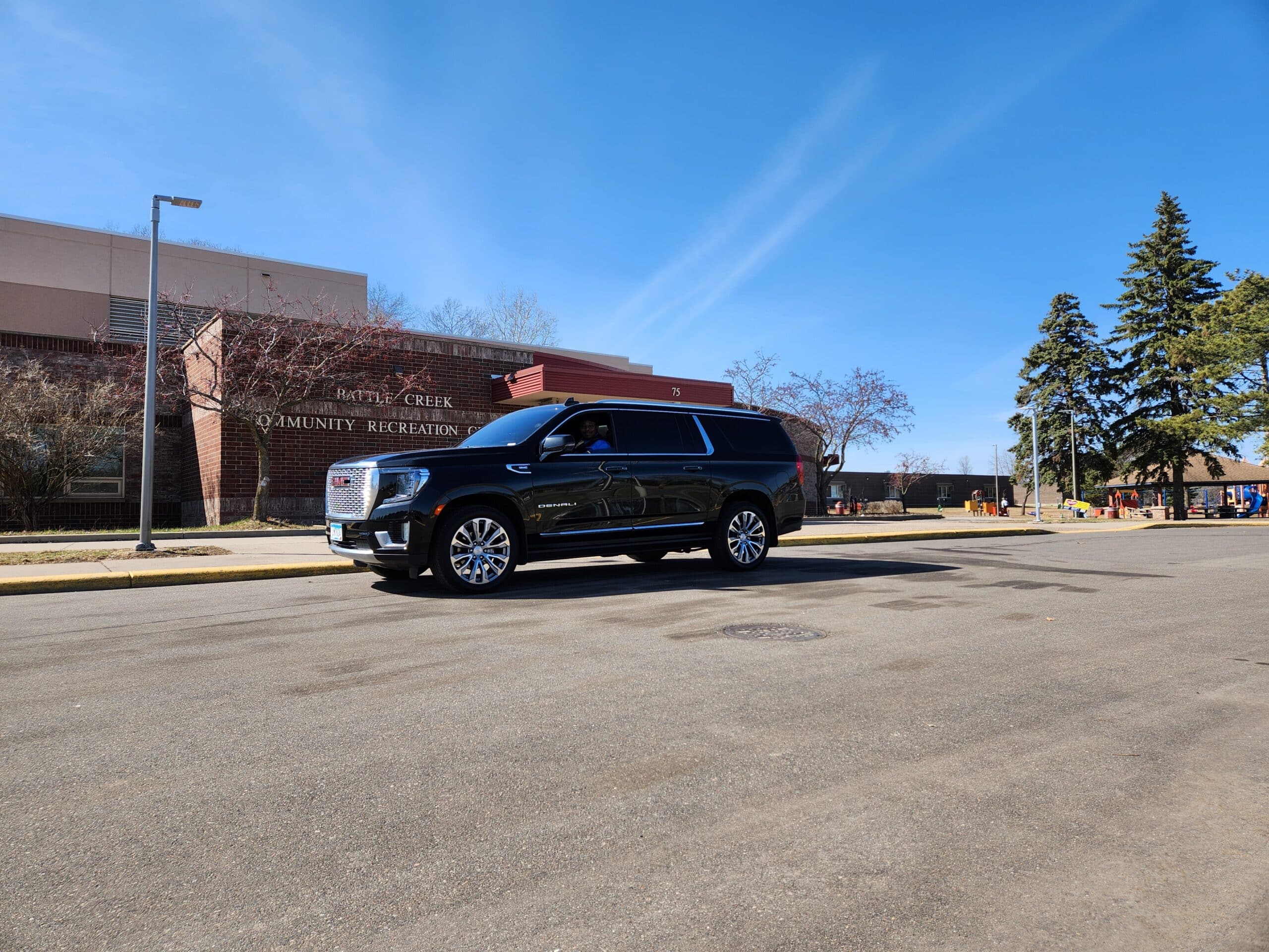 Black CMB Transport vehicle parked in front of downtown Minneapolis skyline at dusk